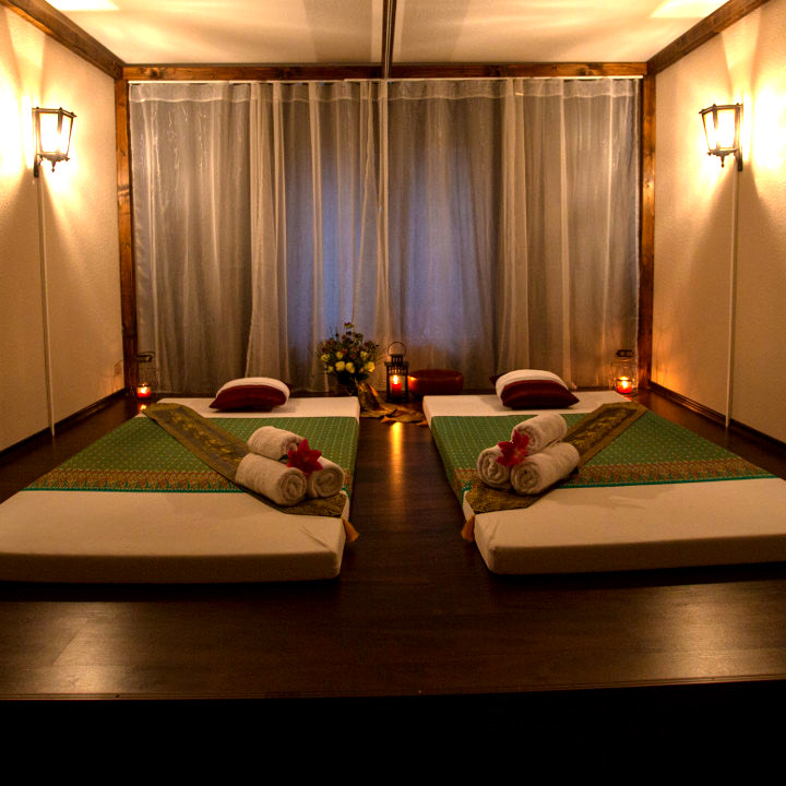 Zwei Thai-Matten in einem Behandlungszimmer mit Vorhang und warmem Lampenlicht